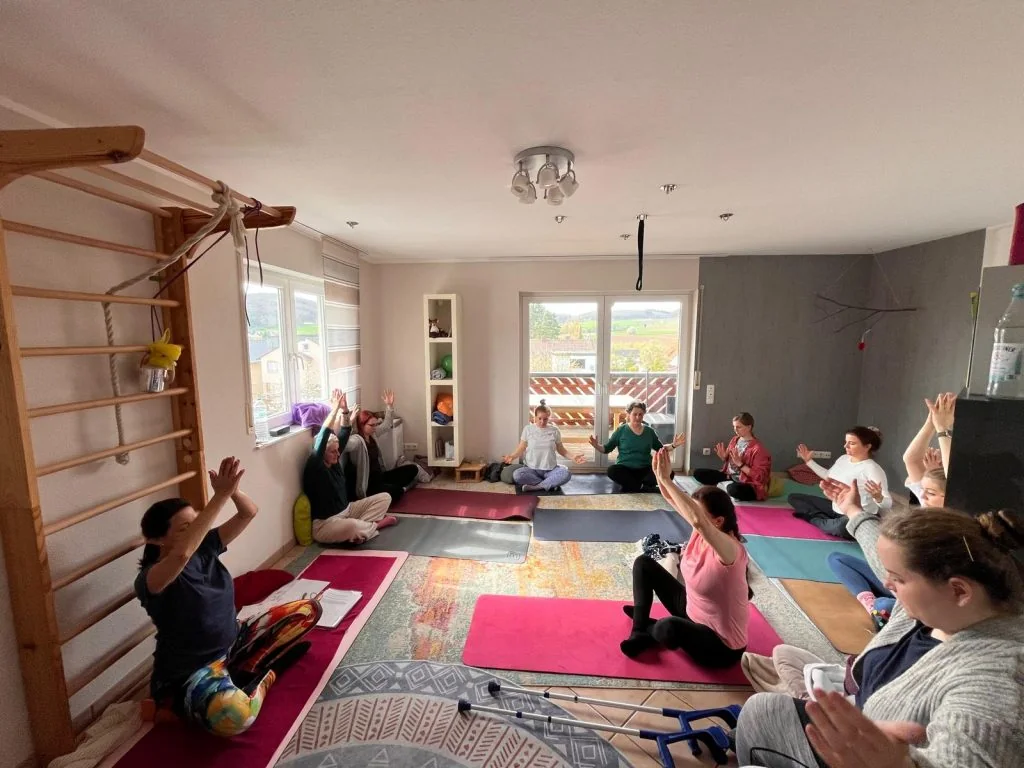 Kunst-und-Yoga-Gruppe in einer gemeinsamen ruhigen Übungsphase