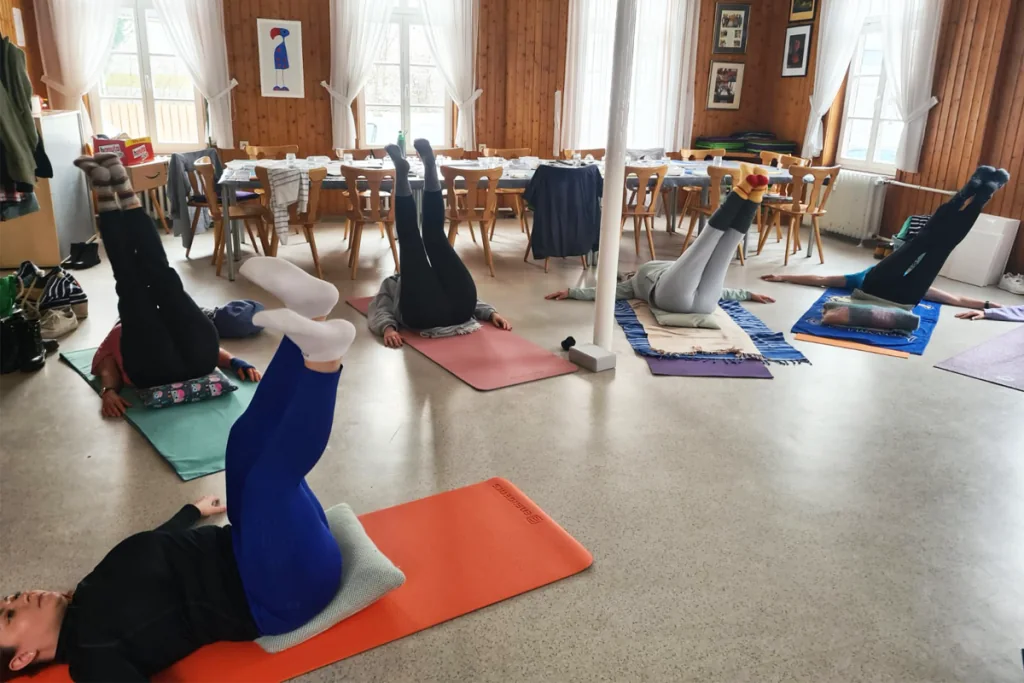 Teilnehmende bei einer angeleiteten Yogaübung im Workshopraum