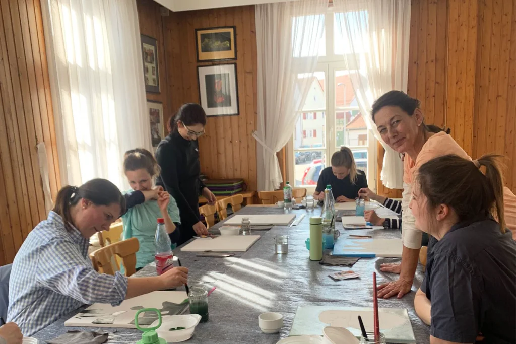 Aurora Schneider begleitet Teilnehmende beim Malen im Kunst-und-Yoga-Workshop